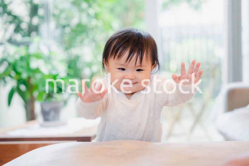 家でつかまり立ちをする赤ちゃん