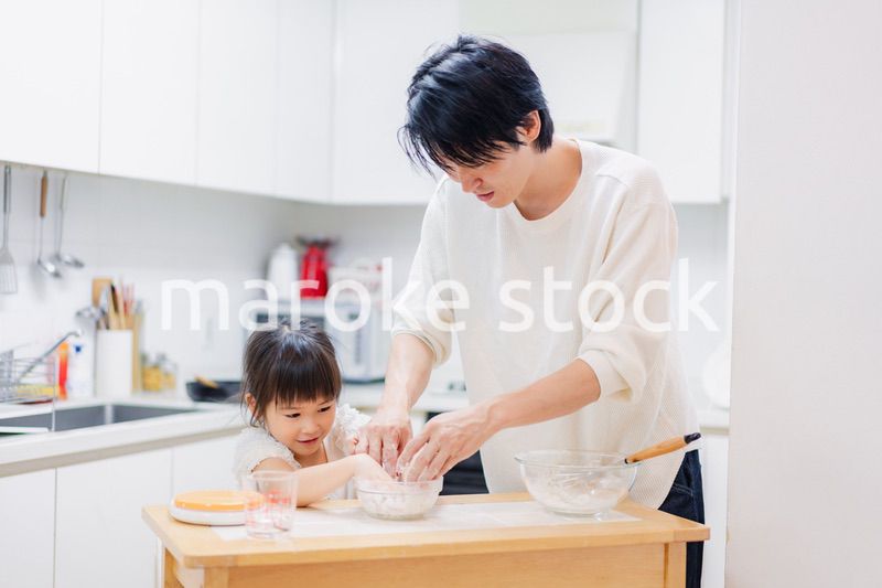 パパと一緒にクッキングをする小さな女の子