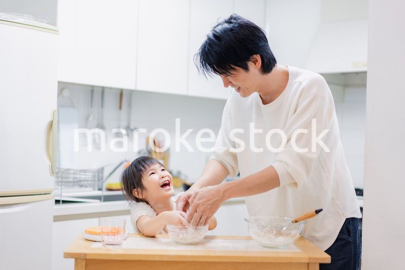 パパと一緒にクッキングをする小さな女の子