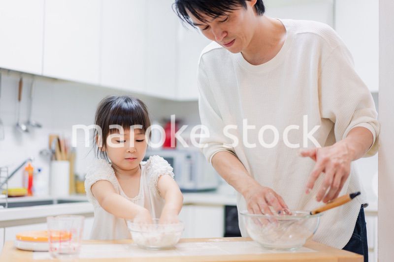 パパと一緒にクッキングをする小さな女の子