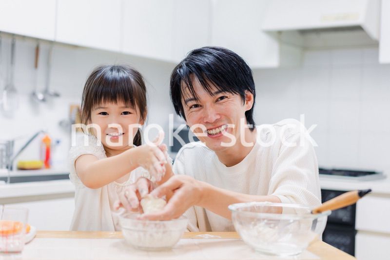パパと一緒にクッキングをする小さな女の子