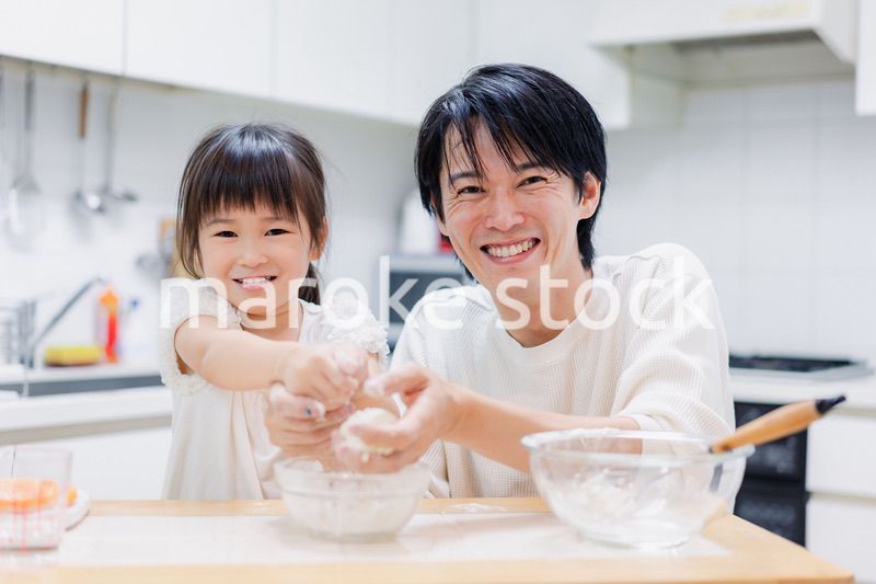 パパと一緒にクッキングをする小さな女の子