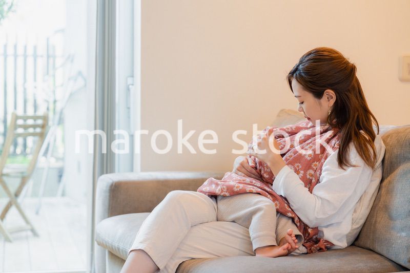 ソファーで赤ちゃんに授乳をするお母さん