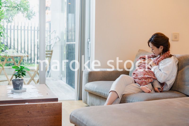 ソファーで赤ちゃんに授乳をするお母さん