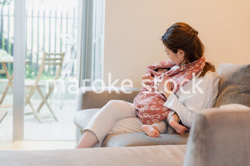 ソファーで赤ちゃんに授乳をするお母さん