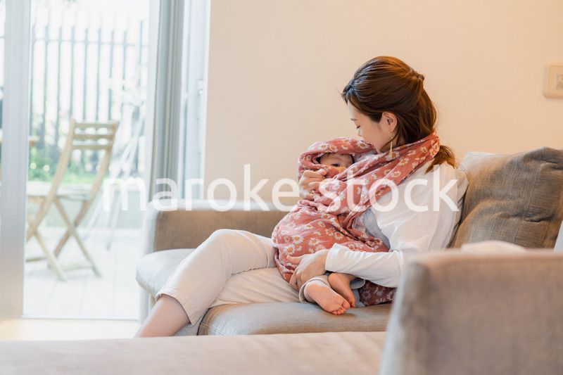 ソファーで赤ちゃんに授乳をするお母さん