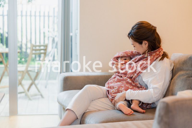 ソファーで赤ちゃんに授乳をするお母さん