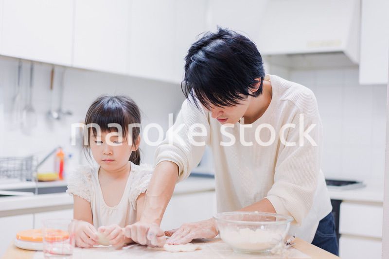 娘と生地をこねるパパ