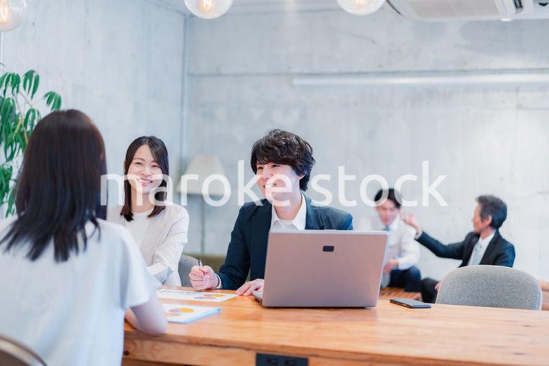 取引先と商談をするビジネスパーソン