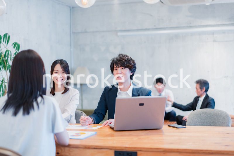 取引先と商談をするビジネスパーソン