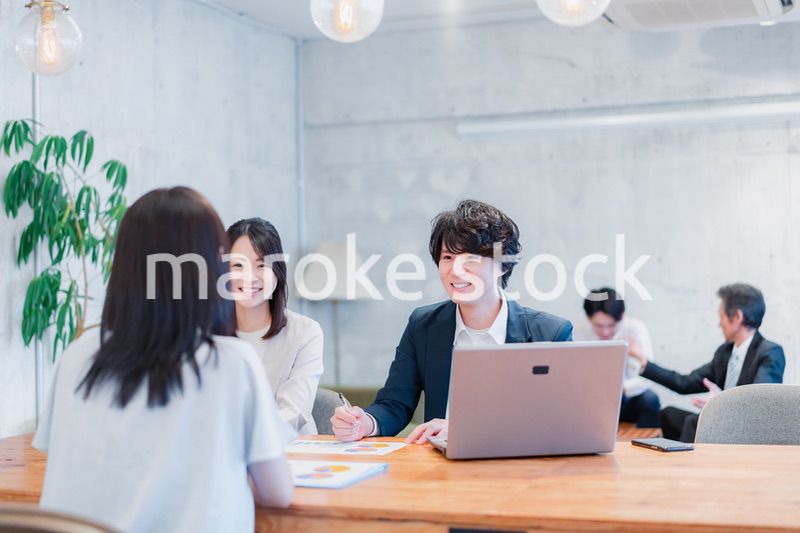 取引先と商談をするビジネスパーソン