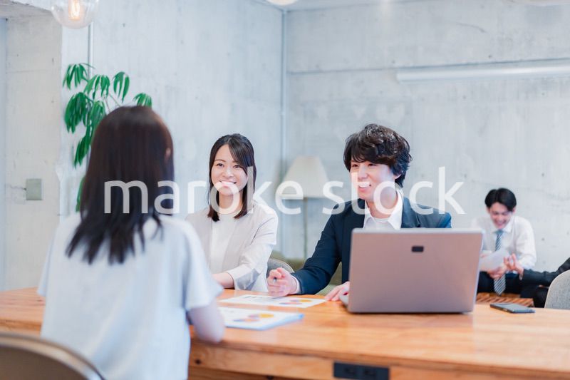 取引先と商談をするビジネスパーソン