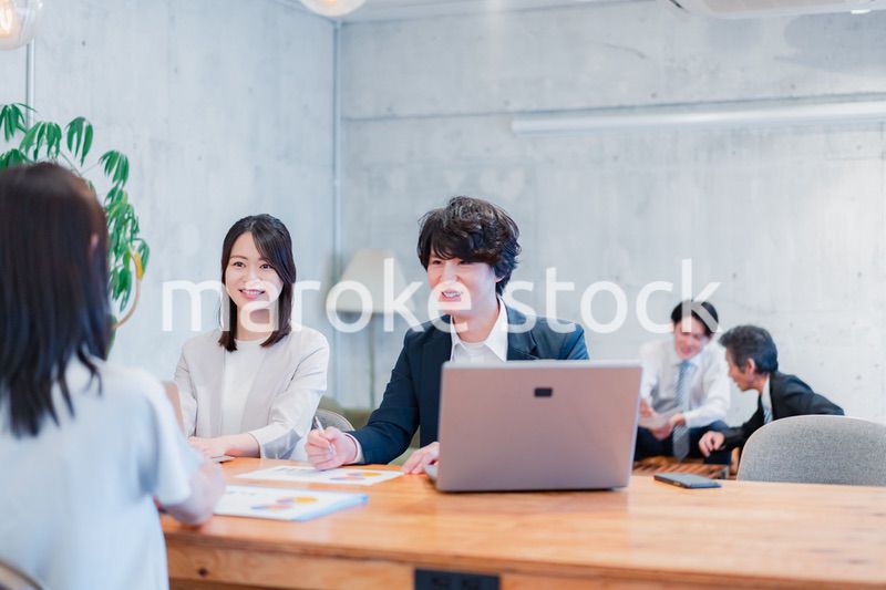 取引先と商談をするビジネスパーソン