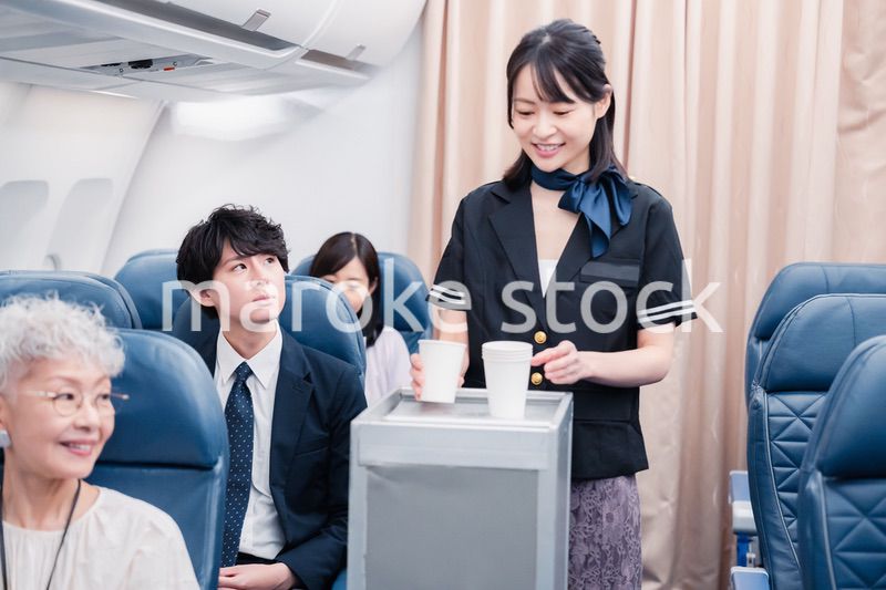 機内で飲み物の提供をするキャビンアテンダント