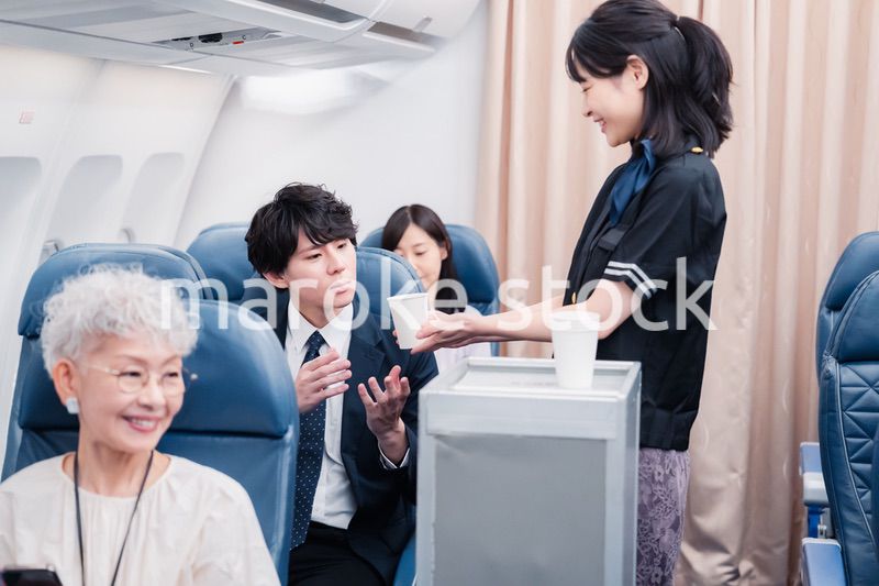機内で飲み物の提供をするキャビンアテンダント