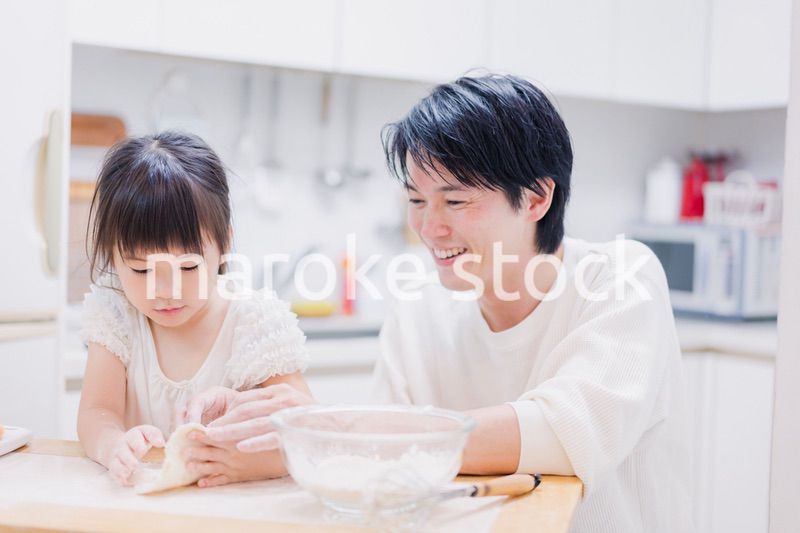 娘と生地をこねるパパ