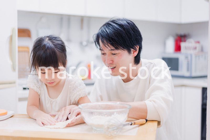 娘と生地をこねるパパ