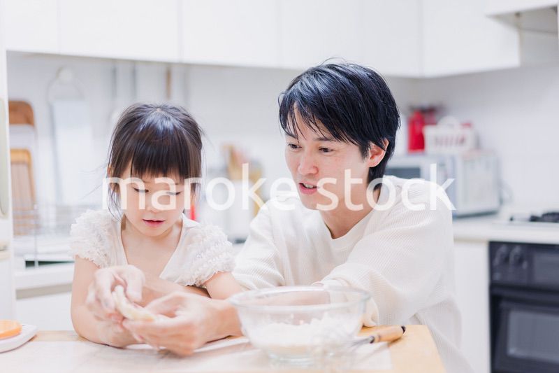 娘と生地をこねるパパ