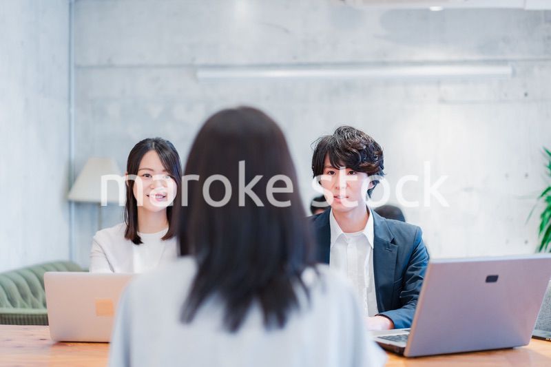 取引先と商談をするビジネスパーソン