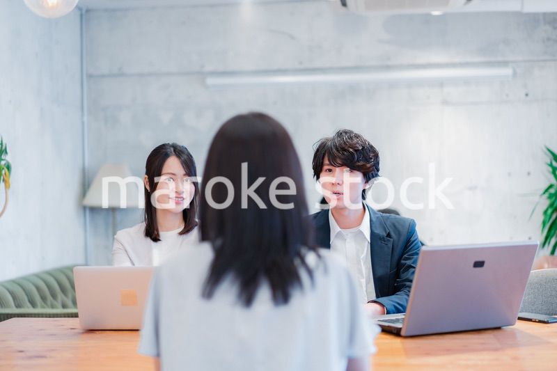 取引先と商談をするビジネスパーソン