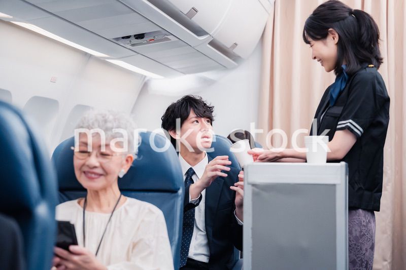 機内で飲み物の提供をするキャビンアテンダント