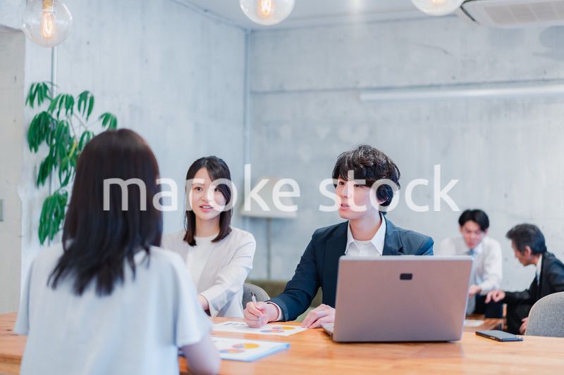 取引先と商談をするビジネスパーソン