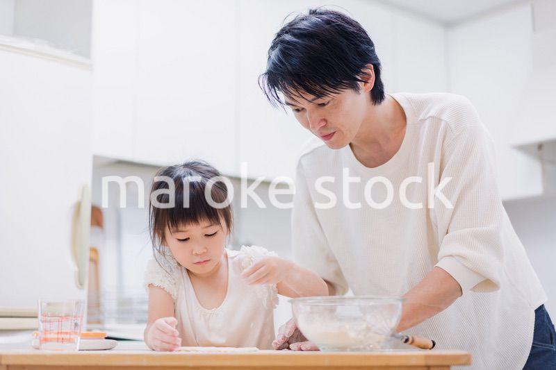 娘と生地をこねるパパ