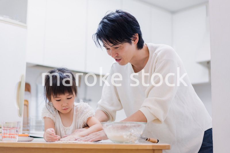 娘と生地をこねるパパ