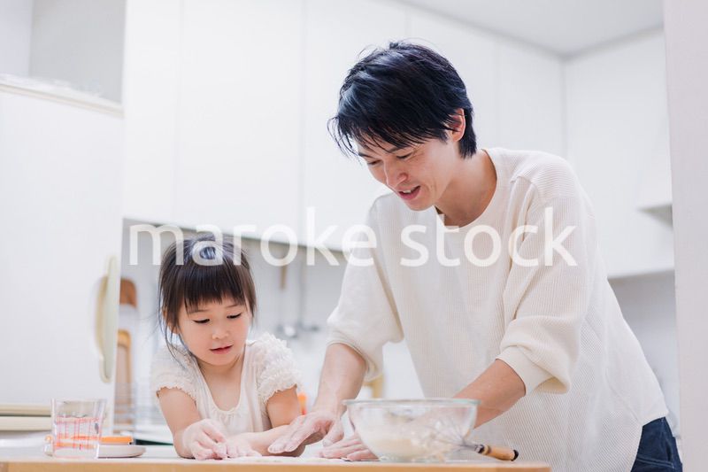 娘と生地をこねるパパ