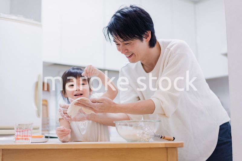 娘と生地をこねるパパ