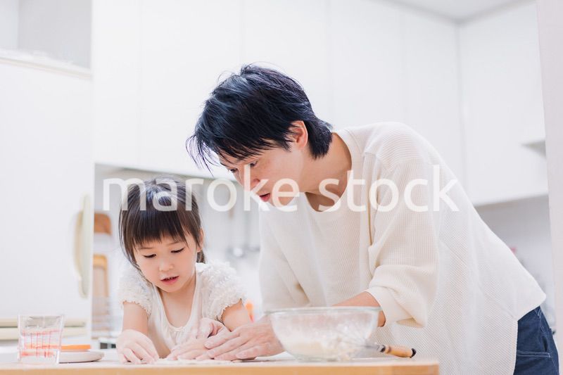 娘と生地をこねるパパ
