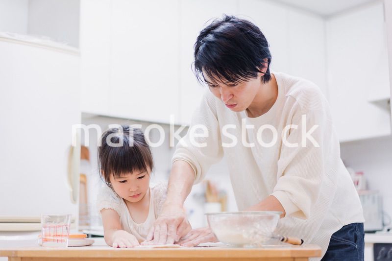 娘と生地をこねるパパ