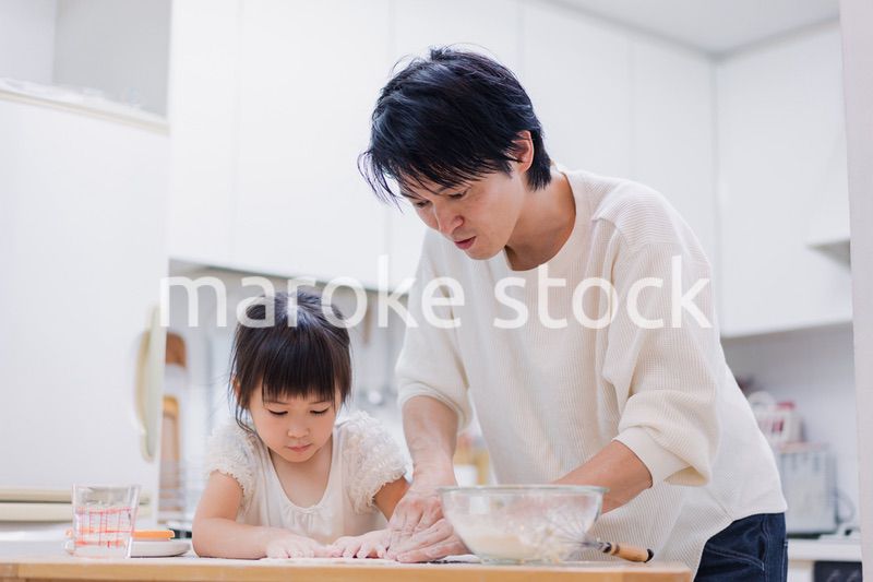 娘と生地をこねるパパ
