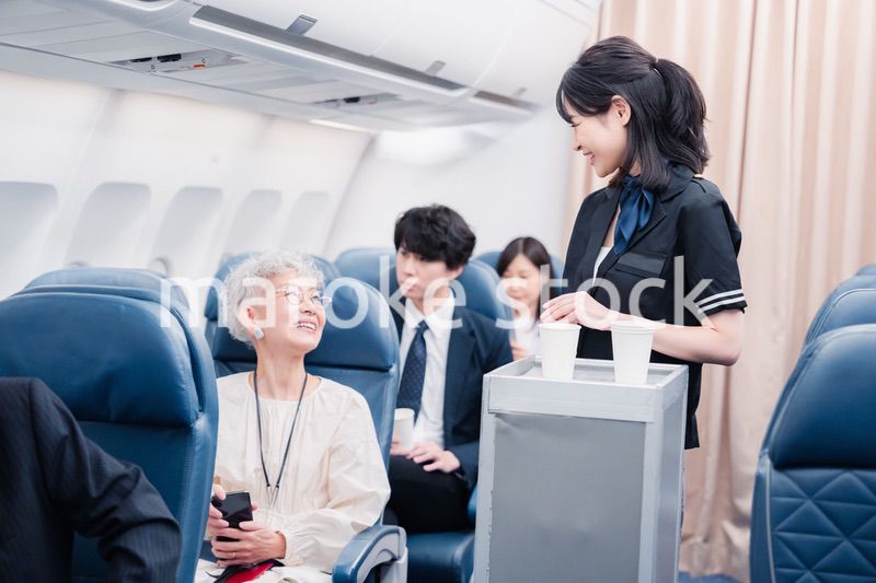 機内で飲み物の提供をするキャビンアテンダント
