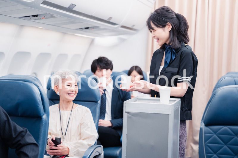 機内で飲み物の提供をするキャビンアテンダント