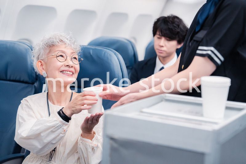 機内で飲み物の提供をするキャビンアテンダント