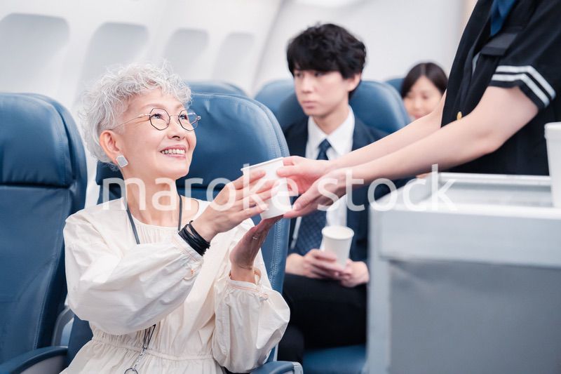 機内で飲み物の提供をするキャビンアテンダント