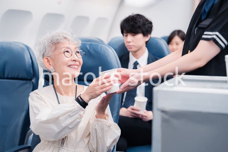 機内で飲み物の提供をするキャビンアテンダント