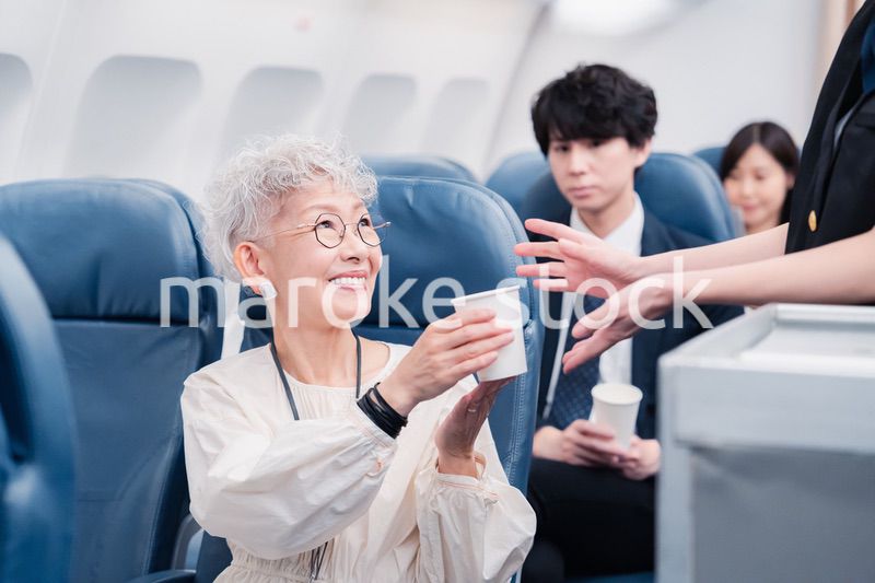 機内で飲み物の提供をするキャビンアテンダント
