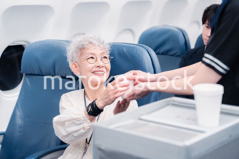 機内で飲み物の提供をするキャビンアテンダント