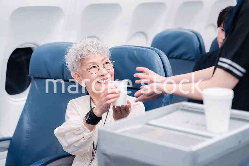 機内で飲み物の提供をするキャビンアテンダント