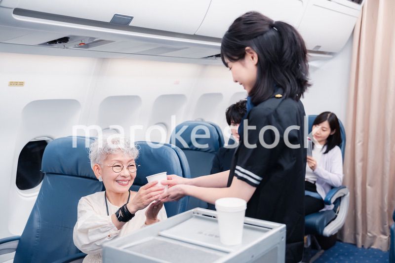 機内で飲み物の提供をするキャビンアテンダント