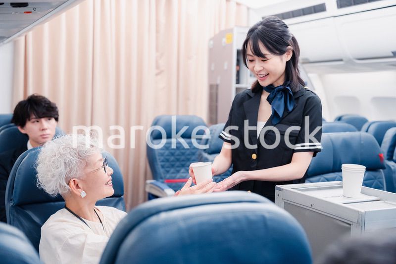 機内で飲み物の提供をするキャビンアテンダント