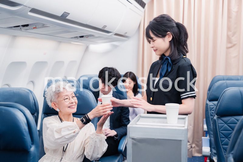機内で飲み物の提供をするキャビンアテンダント