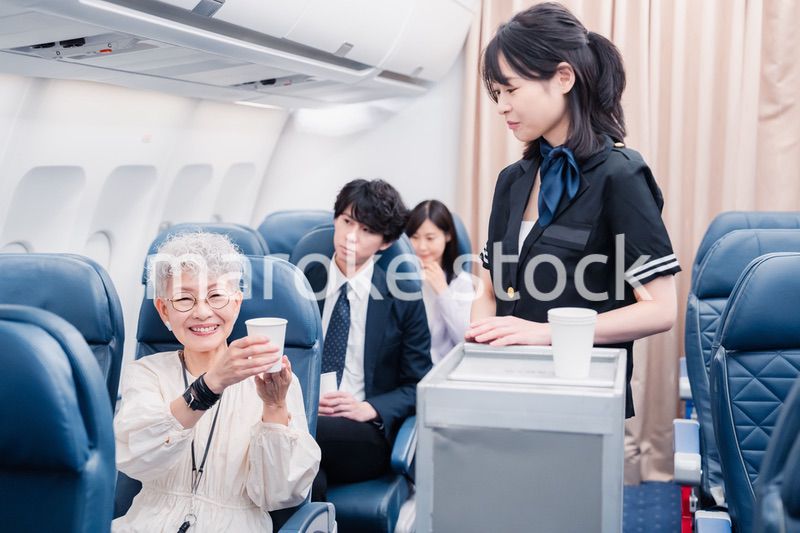 機内で飲み物の提供をするキャビンアテンダント