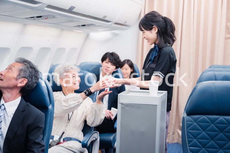 機内で飲み物を提供するキャビンクルー