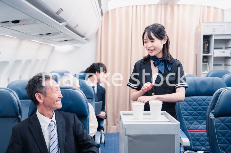 機内で飲み物を提供するキャビンクルー