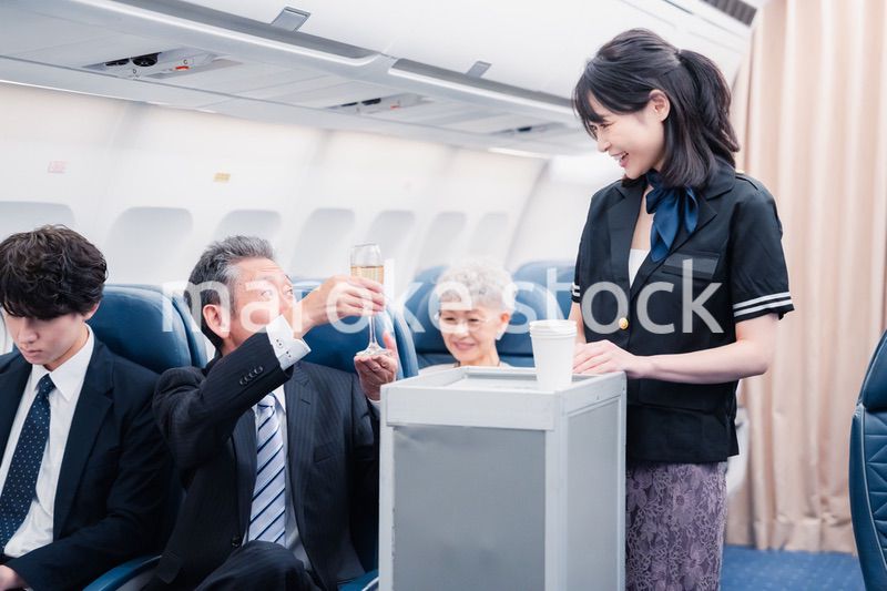 機内で飲み物を提供するキャビンクルー