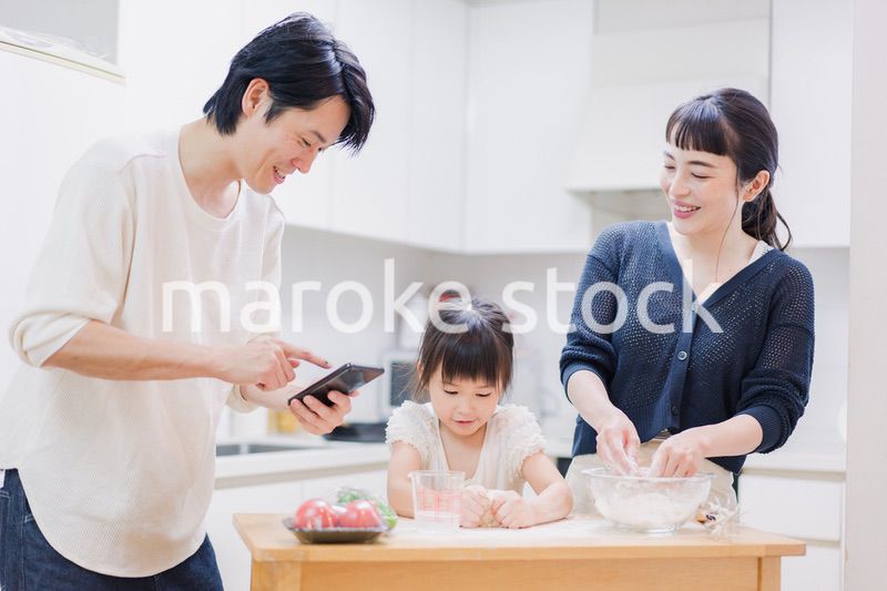 レシピを調べながら料理をするファミリー