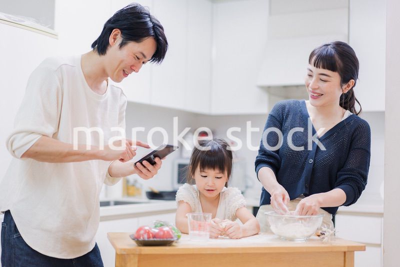 レシピを調べながら料理をするファミリー